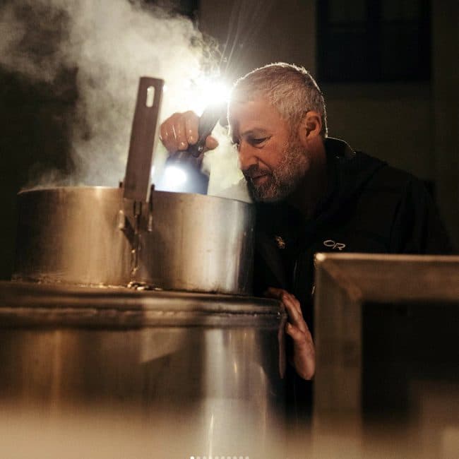 Sierra Nevada founder Ken Grossman looking into a steaming large kettle